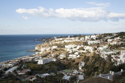 High angle view of townscape by sea against sky