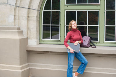 Young caucasian girl going back to college, school, standing with a notebooks