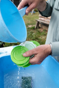 Midsection of man pouring water in container