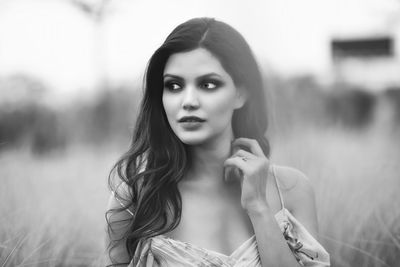 Portrait of beautiful young woman in field