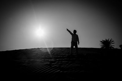Low angle view of sun shining through clouds