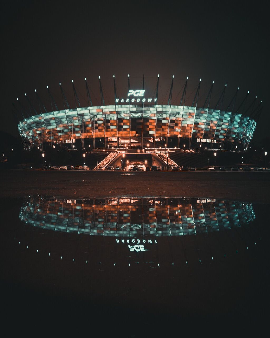 AERIAL VIEW OF ILLUMINATED BUILDINGS AGAINST SKY AT NIGHT