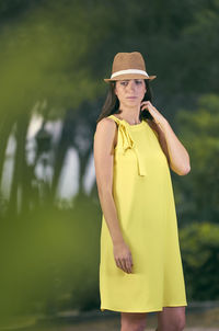 Portrait of young woman wearing hat standing outdoors