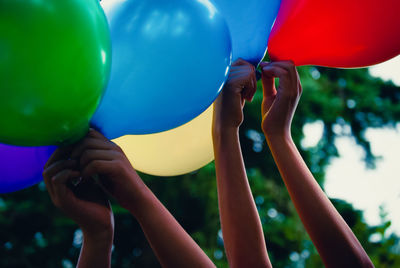 Kinderhände halten bunte luftballons in die höhe 