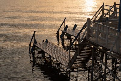 Silhouette pier on sea against sky during sunset