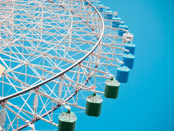 Low angle view of ferris wheel against blue sky