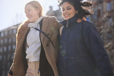 Female friends walking together ourdoors on walkway in city