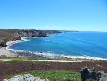 Scenic view of cliff by sea against sky