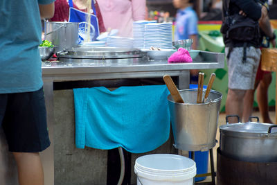 Rear view of noodle station in food market for cooking with blurred sellers