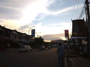 Cars on road against sky during sunset