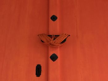 Close-up of lamp against orange wall