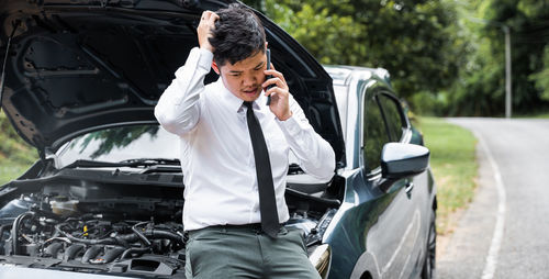 Side view of young man using mobile phone