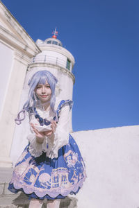 Woman on cosplay standing against sky