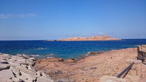 Scenic view of beach against clear blue sky