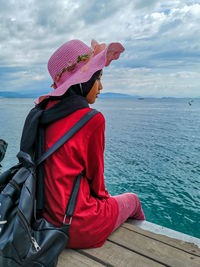 Side view of woman looking at sea against sky