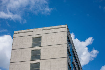 Low angle view of modern building against blue sky