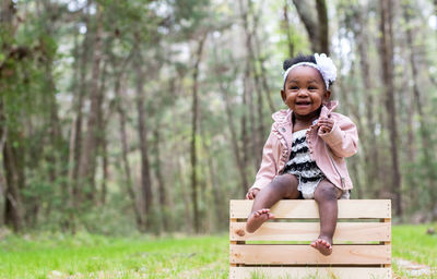 Portrait of smiling girl sitting on tree