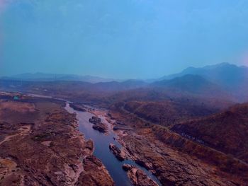 Aerial view of landscape and mountains against blue sky