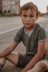 Portrait of boy sitting on road