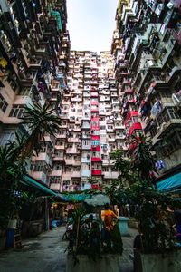 Low angle view of street amidst buildings in city against sky