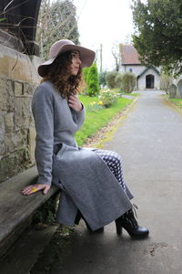 Portrait of young woman sitting on tree