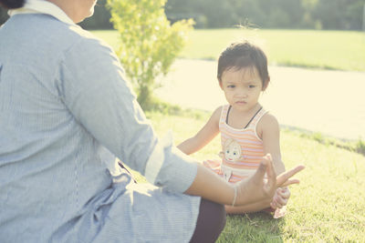 Full length of young woman sitting on field