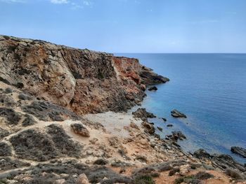 Rock formations by sea against sky