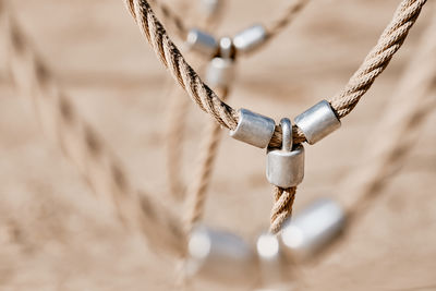 Close-up of rope tied to metal chain