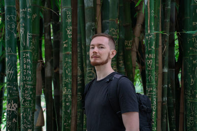 Portrait of young man standing in forest