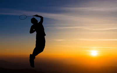 Silhouette of man jumping against sky during sunset