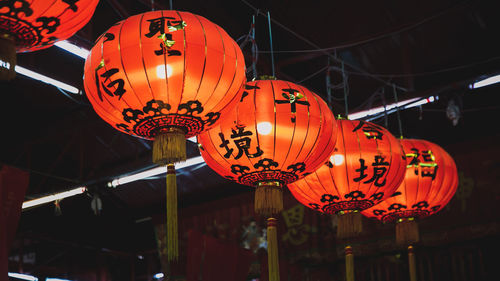 Low angle view of illuminated lanterns hanging at night