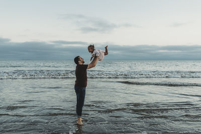 Full length of man standing on beach against sky