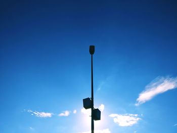 Low angle view of street light against blue sky