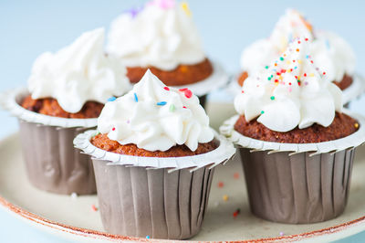 Carrot cake cupcakes with cream cheese frosting with sprinkles. close up. copy space.