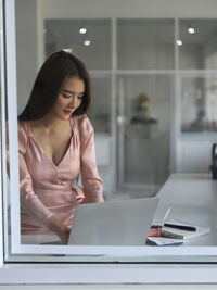 Woman working on laptop while sitting on table