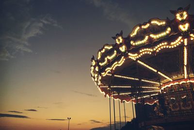 Low angle view of illuminated ferris wheel against sky at night