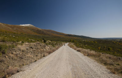 Landscape of dirt road leading towards mountain against clear sky, in guadalajara, spain