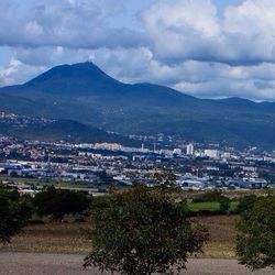 View of cityscape against cloudy sky