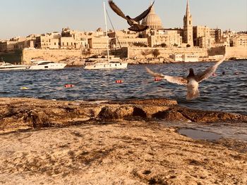 Scenic view of sea and buildings against sky