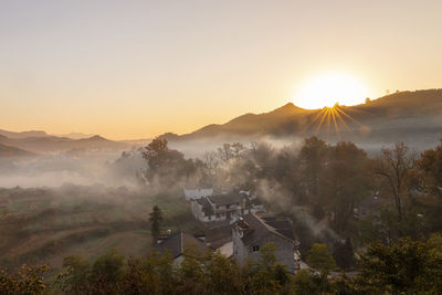 At sunrise, the mountain and sky scenery in the village