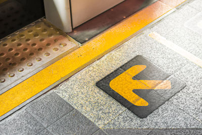 High angle view of arrow sign on floor in city
