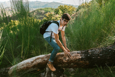 Young man standing on land against trees