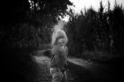 Portrait of smiling girl standing against trees