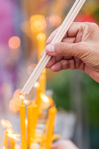 Close-up of hand lighting incenses