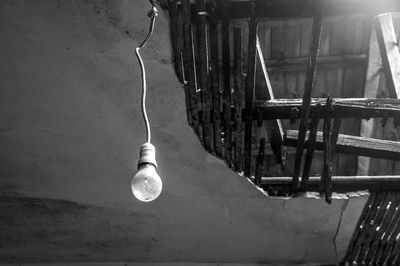 Low angle view of light bulb hanging on ceiling