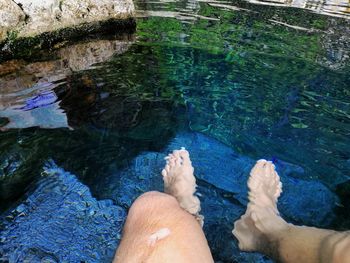 Low section of man relaxing in swimming pool