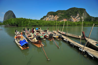 Boats moored in sea against clear sky