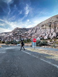 Man standing on road against mountain range