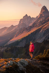 Full length of man standing on rocks against mountain