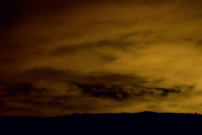 Low angle view of silhouette landscape against sky at sunset